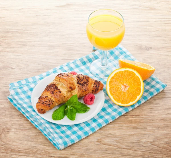 Orange juice och färsk croissant — Stockfoto