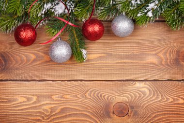 Kar ve rustik ahşap tahta üzerinde baubles ile Noel köknar ağacı