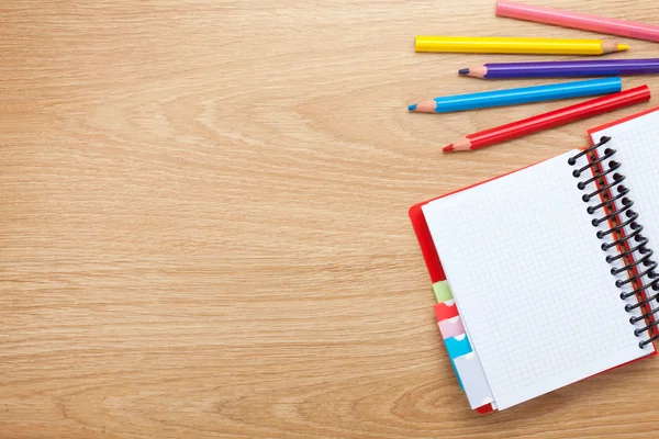 Table de bureau avec bloc-notes vierges et crayons colorés — Photo