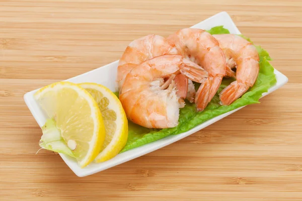 Cooked shrimps with lemon and salad leaves — Stock Photo, Image