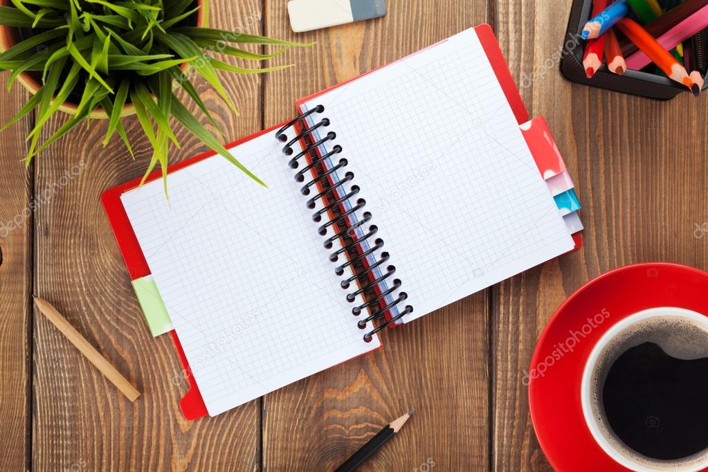 Office table with flower, blank notepad and coffee cup