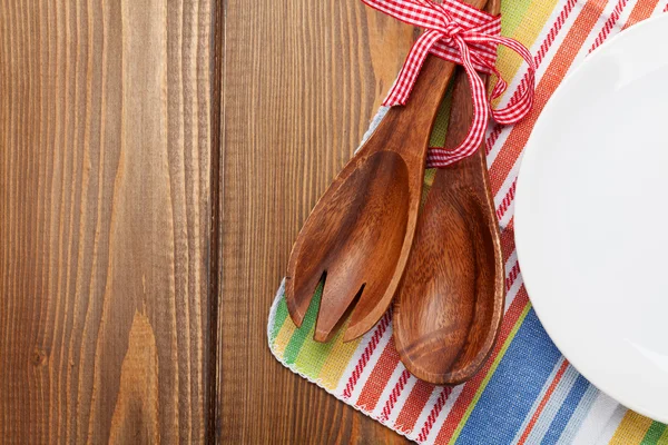 Кухонные принадлежности из дерева и пустая тарелка — стоковое фото