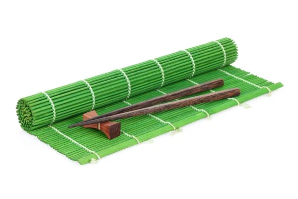 Eetstokjes over bamboe mat — Stockfoto