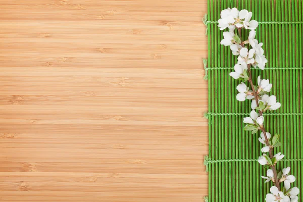 Sakura-ág felett bambusz mat — Stock Fotó