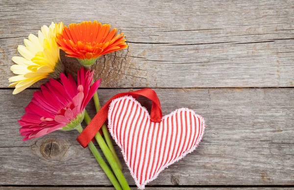 Renkli gerbera çiçekleri ve kalp oyuncak — Stok fotoğraf