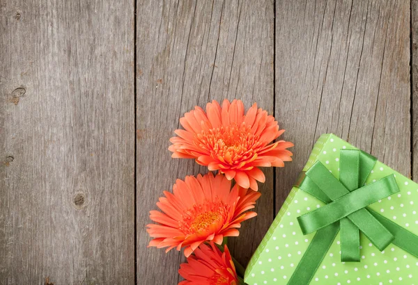 Turuncu gerbera çiçekleri ve hediye kutusu — Stok fotoğraf