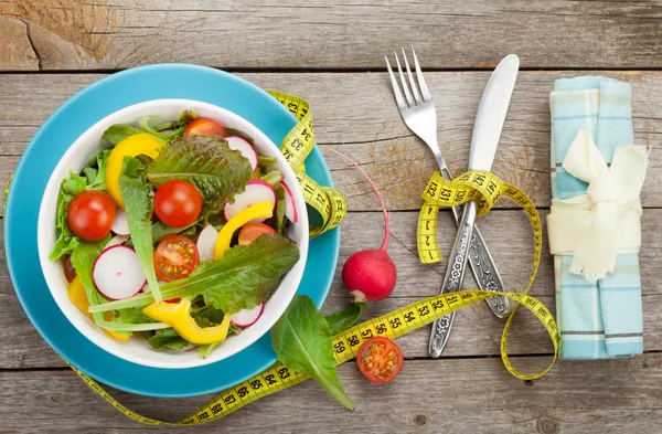 Fresh healthy salad and measuring tape — Stock Photo, Image