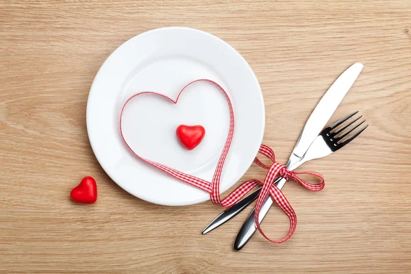 Día de San Valentín corazón en forma de cinta roja sobre el plato con silverwa —  Fotos de Stock