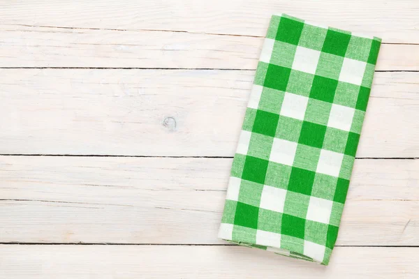 Green towel over wooden kitchen table — Stock Photo, Image