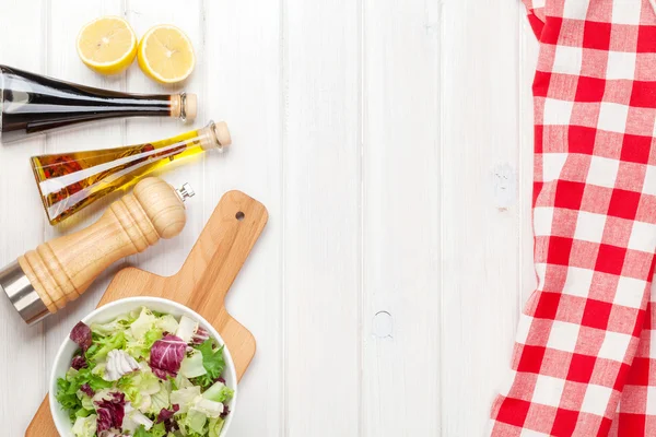Salade fraîche et saine et condiments sur table en bois blanc — Photo