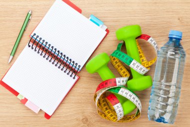 Dumbells, mezura ve kopya alanı için not defteri.