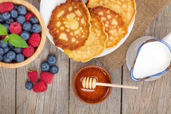 Pannenkoeken met frambozen, bosbessen, melk en honing siroop — Stockfoto