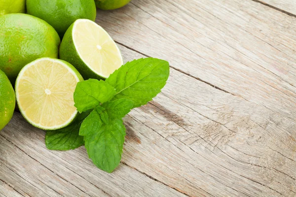 Fresh ripe limes with mint — Stock Photo, Image