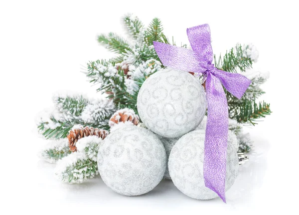 Christmas baubles and purple ribbon with snow fir tree — Stock Photo, Image