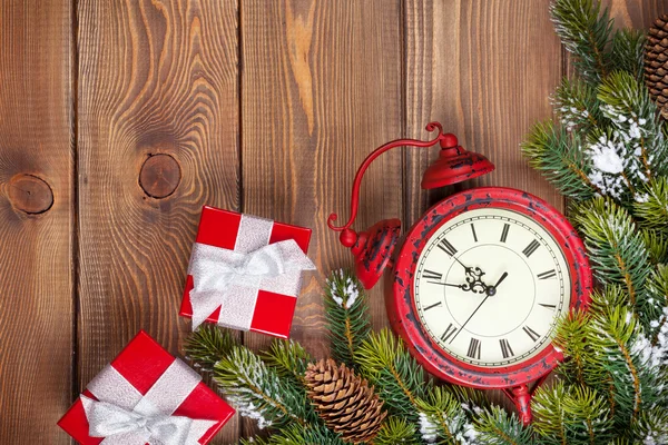 Рождественский фон с часами, подарочными коробками и снежной пищей — стоковое фото