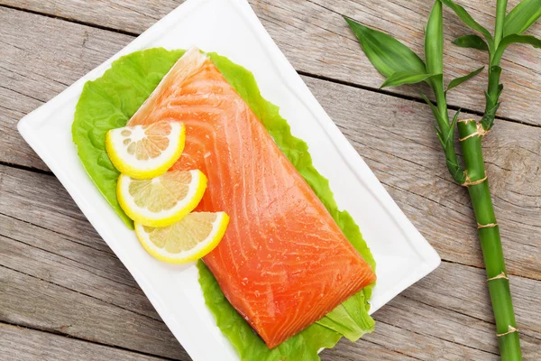 Fresh salmon fish with lemon and salad leaves — Stock Photo, Image