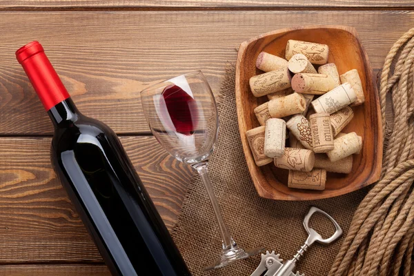 Botella de vino tinto con vidrio y corchos — Foto de Stock