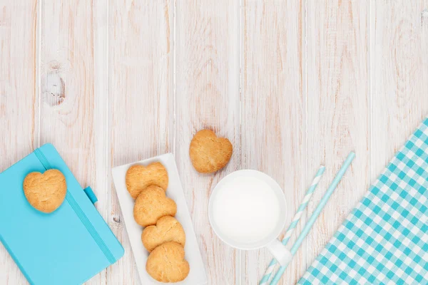 Copo de leite e biscoitos em forma de coração — Fotografia de Stock