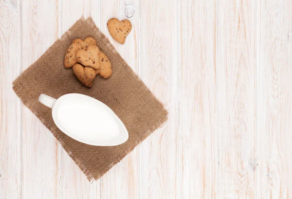 Kruik van melk en hart gevormde cookies — Stockfoto