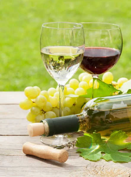 Wine glasses and bottle with grapes — Stock Photo, Image