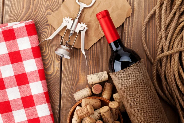 Kırmızı şarap şişesi, mantarlar ve tirbuşon bir kase — Stok fotoğraf