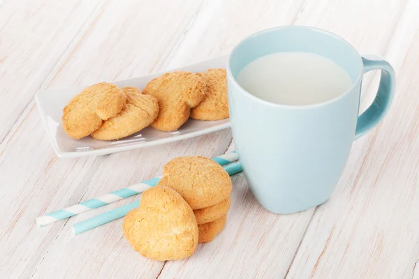 Cup of milk and heart shaped cookies — Stock Photo, Image