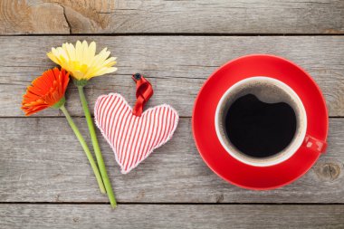Fincan kahve, kalp oyuncak ve gerbera çiçekleri