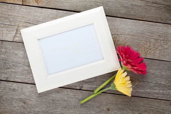 Two colorful gerbera flowers and photo frame — Stock Photo, Image