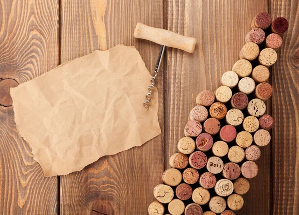 Rolhas em forma de garrafa de vinho, saca-rolhas e papel — Fotografia de Stock