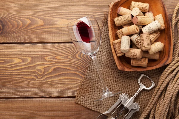 Pohár vörösbor, dugók és dugóhúzó — Stock Fotó