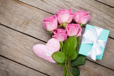 Ahşap masanın üzerinde pembe güller