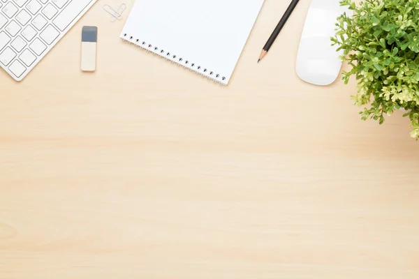 Bürotisch mit Notizblock, Computer und Blume — Stockfoto