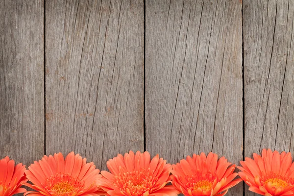 Houten achtergrond met oranje gerbera 's — Stockfoto