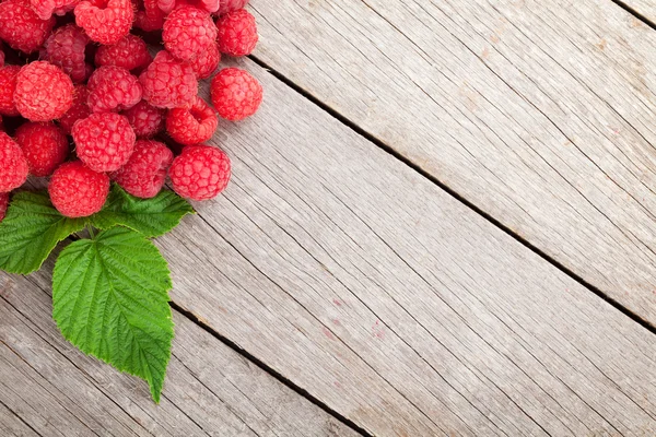 Verse rijpe frambozen op houten tafel — Stockfoto