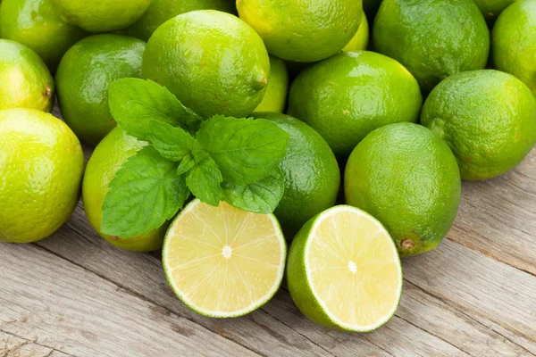 Frische reife Limetten mit Minze — Stockfoto