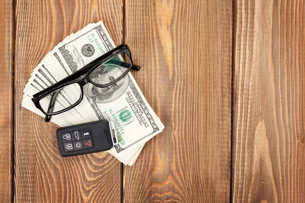 Money cash, glasses and car remote key on wooden table — Stock Photo, Image