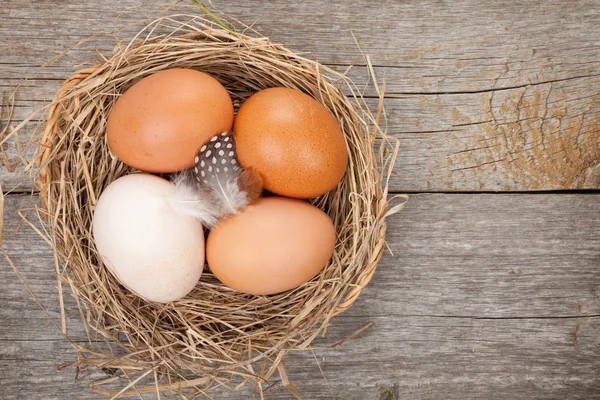 Eggs nest over wooden table — Stock Photo, Image
