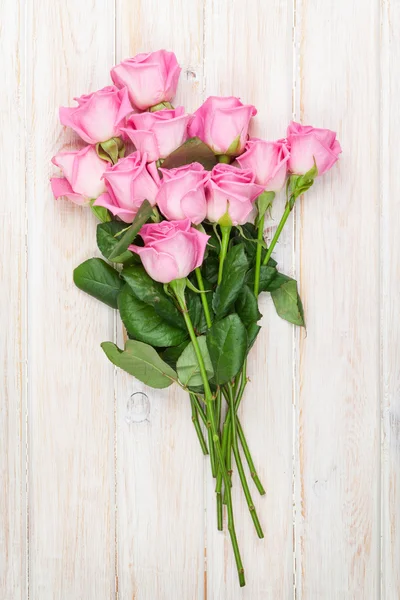 Ramo de rosas rosadas sobre mesa de madera — Foto de Stock