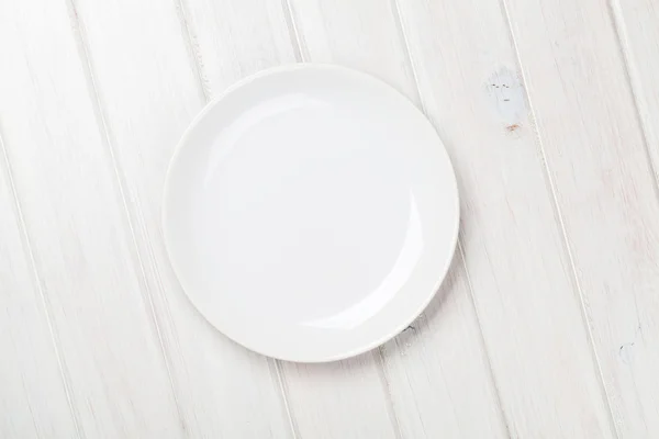 Empty plate over wooden table — Stock Photo, Image