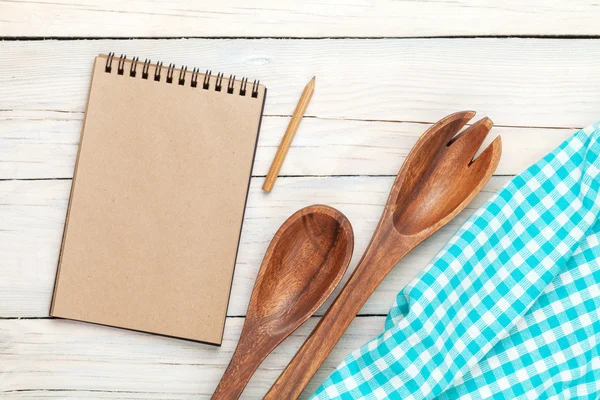 Blocco note su strofinaccio da cucina e utensili su tavolo di legno — Foto Stock