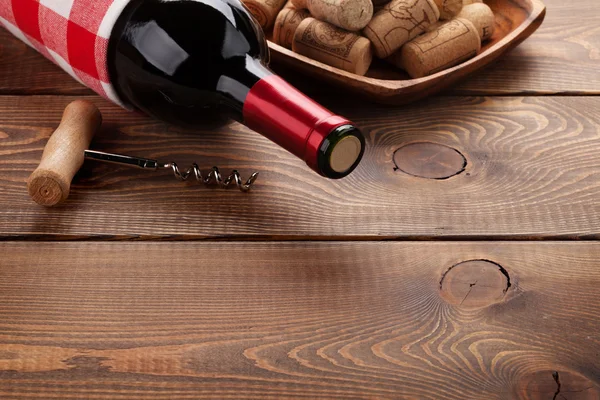 Бутылка красного вина, пробки и штопор — стоковое фото