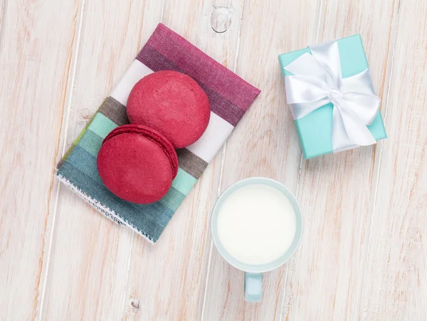 Macarons, cup of milk and gift box