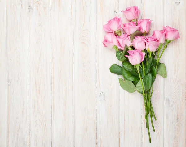 Rosa Rosen Strauß über Holztisch — Stockfoto