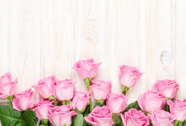 Ramo de rosas rosadas sobre mesa de madera — Foto de Stock