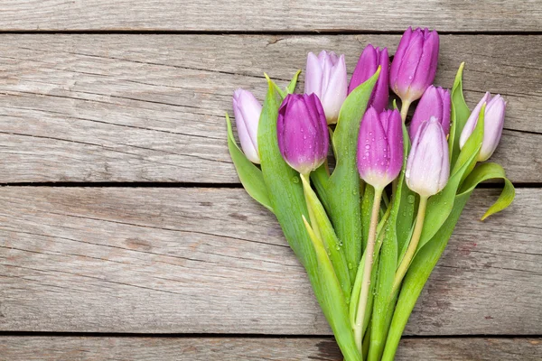 Purple tulips on wooden table — Stock Photo, Image