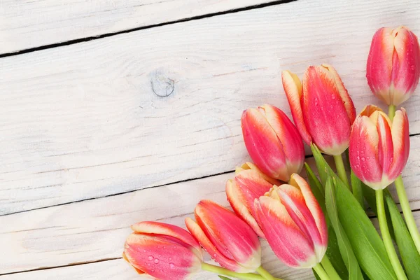 Tulipanes coloridos en mesa de madera — Foto de Stock