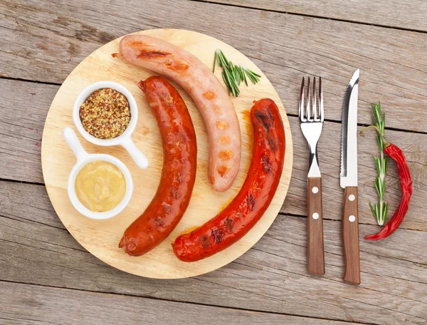 Grilled sausages with condiments — Stock Photo, Image