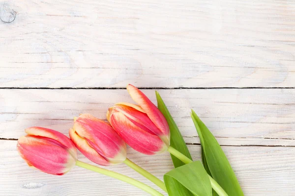 Tulipanes coloridos en mesa de madera — Foto de Stock