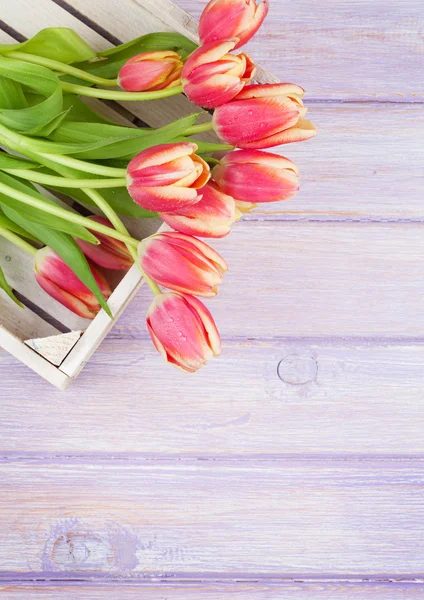 Pomarańczowe tulipany na drewnianym stole — Zdjęcie stockowe