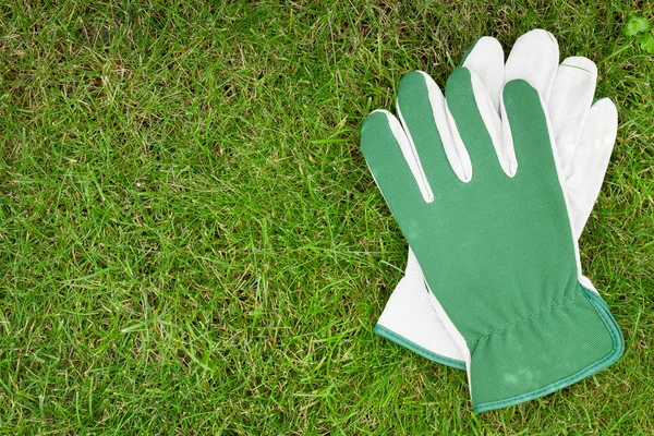 在绿色草地上的花园手套 — 图库照片